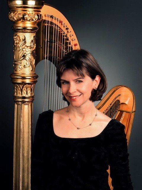 Nancy Allen smiling beside her harp