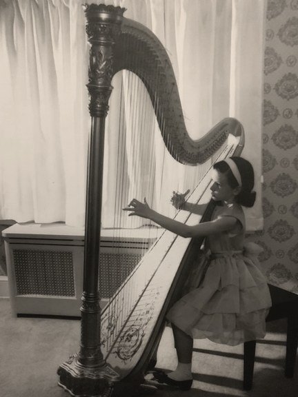 Nancy Allen as a young girl playing the harp